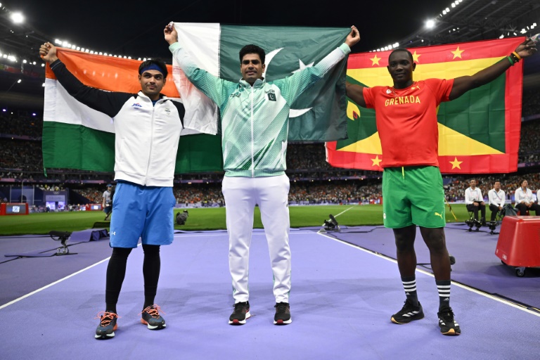L'Indien Neeraj Chopra (à gauche), médaillé d'argent, le Pakistanais Arshad Nadeem (au centre), médaille d'or, et le Grenadin Anderson Peters, médaillé de bronze, posent sur le podium du javelot, le 8 août 2024 aux Jeux olympiques de Paris