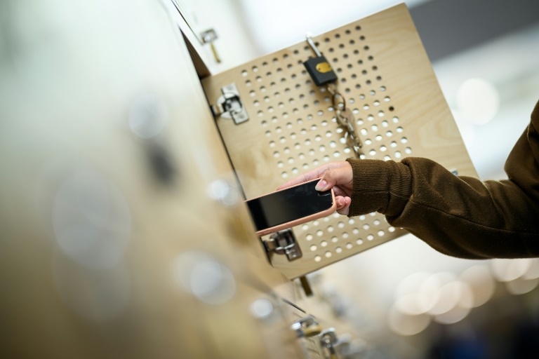 Une élève range son téléphone portable dans un casier après l'avoir éteint, dans un lycée à Lorient, le 5 septembre 2024