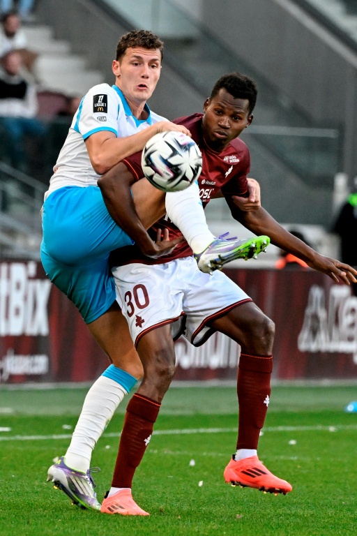 Le défenseur de l'OM Benjamin Pavard (g) à la lutte avec l'attaquant de Metz Habib Diallo lors de la victoire de Marseille (3-0), le 4 octobre 2025 au stade Saint-Symphorien de Metz