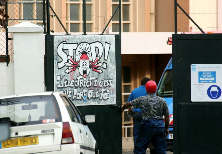 Des employés d'EDF quittent l'enceinte du transformateur EDF de Clichy-sous-Bois, le 28 octobre 2005 en Seine-Saint-Denis, où deux mineurs sont morts par électrocution dans la nuit en tentant d'échapper à la police