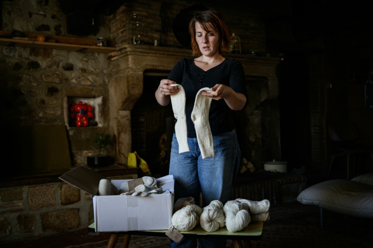 Chloé Pimont, une comédienne parisienne et végétarienne devenue éleveuse de brebis dans le Morvan, montre des chaussettes faites avec la laine de ses moutons, le 29 septembre 2025 à Monthelon, en Saône-et-Loire