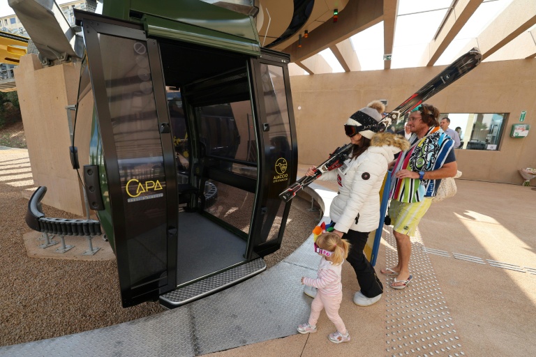 Trois personnes déguisées en vacanciers pénètrent dans la cabine du téléphérique urbain d'Ajaccio à l'occasion de son inauguration, le 18 octobre 2025