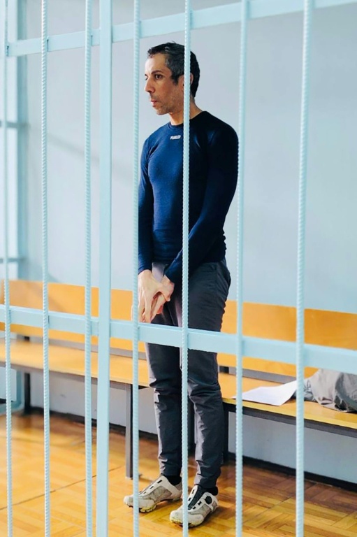 Photo du 23 octobre 2025 publiée par le service de presse unifié des tribunaux de la région de Primorié, montrant le cycliste français Sofiane Sehili, arrêté pour suspicion d'avoir traversé illégalement la frontière russe, dans la cage des accusés lors d'une audience au tribunal dans la colonie extrême-orientale de Pogranitchny