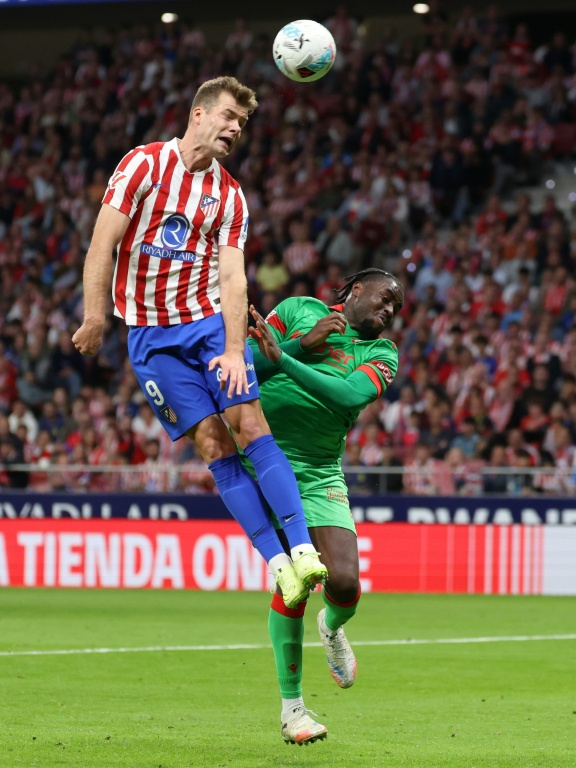 Le joueur de l'Atlético Alexander Sorloth (G) domine de la tête le défeuseur d'Osasuna Flavien Boyomo lors de la courte victoire des Madrilènes en Liga (1-0), le 18 octobre 2025 au Metropolitano Stadium