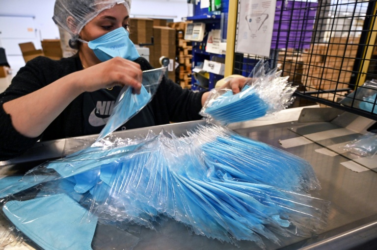 Une employé emballe des masques de protection sur une chaîne de montage d'une usine de fabrication à Mably, le 28 février 2020 dans la Loire