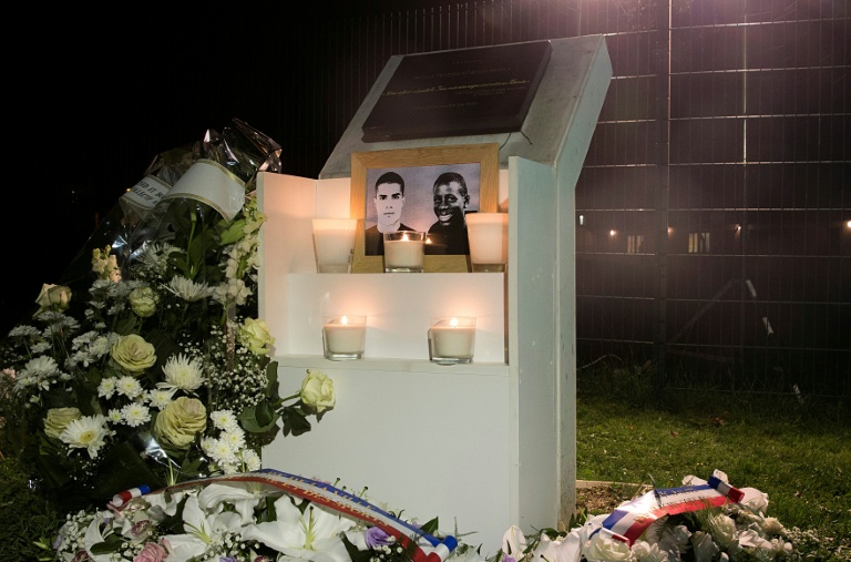Des fleurs déposées près d'une plaque érigée à la mémoire de Bouna Traoré (d) et Zyed Benna, deux adolescents décédés en fuyant la police le 27 octobre 2005, à Clichy-sous-Bois, le 27 octobre 2015 en Seine-Saint-Denis