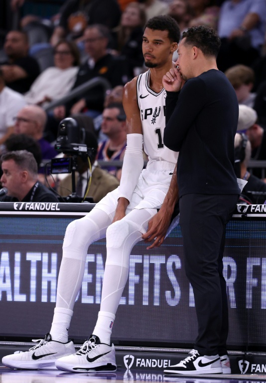 L'entraîneur des San Antonio Spurs Mitch Johnson (d) parle avec son joueur Victor Wembanyama lors du match NBA contre les Phoenix Suns, le 2 novembre 2025 à Phoenix
