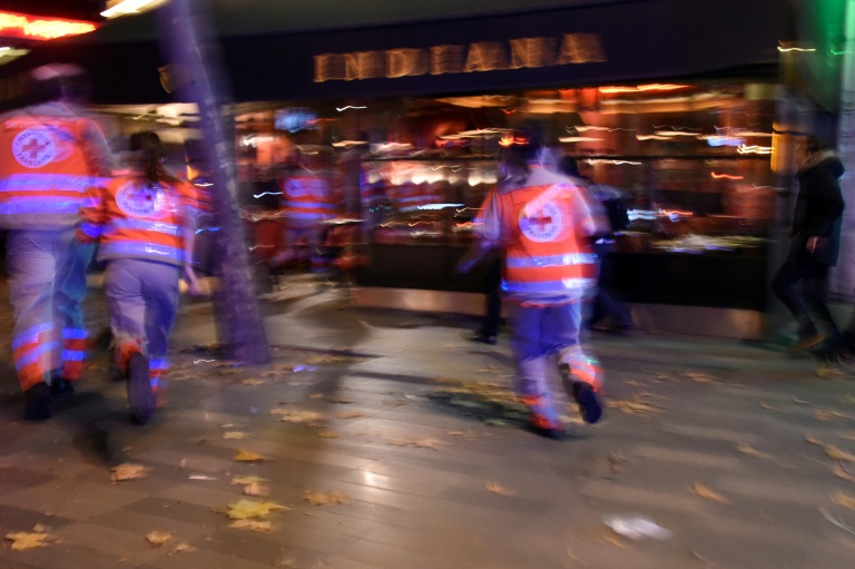 Des membres de la Croix-Rouge courent après avoir entendu des déflagrations près de la place de la République à Paris, le 13 novembre 2015