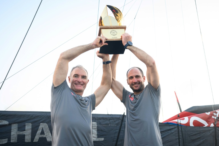 Jérémie Beyou et Morgan Lagraviere soulèvent le trophée après leur victoire en Imoca sur la Transat Café l'Or, à Fort-de-France en Martinique le 7 Novembre 2025.