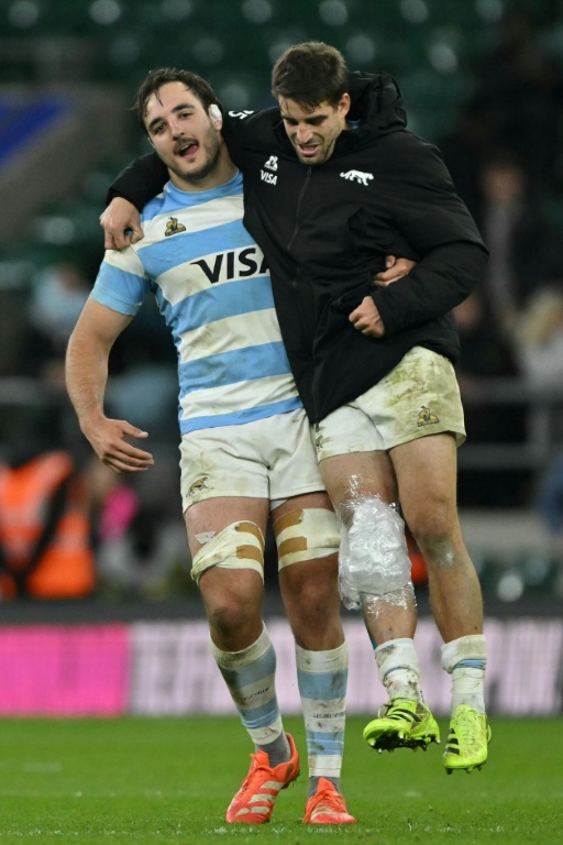 L'arrière argentin Juan Cruz Mallia, genou droit dans la glace, soutenu par son coéquipier Franco Molina à la fin du match perdu par les Pumas face à l'Angleterre (27-23) le 23 novembre 2025 à Twickenham