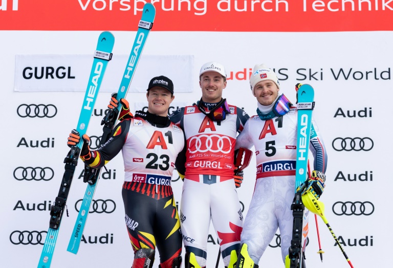 Les skieurs belge Armand Marchant (à gauche), français Paco Rassat (au centre) et norvégien Atle Lie McGrath (à droite), respectivement 3e, 1er et 2e, sur le podium du slalom de la Coupe du monde de ski alpin à Gurgl (Autriche) le 22 novembre 2025.