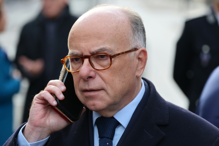 L'ancien Premier ministre Bernard Cazeneuve parle au téléphone avant une cérémonie rendant hommage aux victimes du 13-Novembre devant le Stade de France à Saint-Denis, le 13 novembre 2025