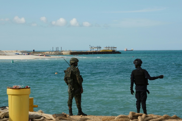 Un policier (d) et un soldat rwandais montent la garde près du projet Total Mozambique LNG à Afungi, dans la province de Cabo Delgado, au Mozambique, le 29 septembre 2022