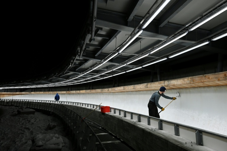 Un membre de l'encadrement prépare la piste olympique de bobsleigh à Cortina d'Ampezzo (Italie) le 20 novembre 2025