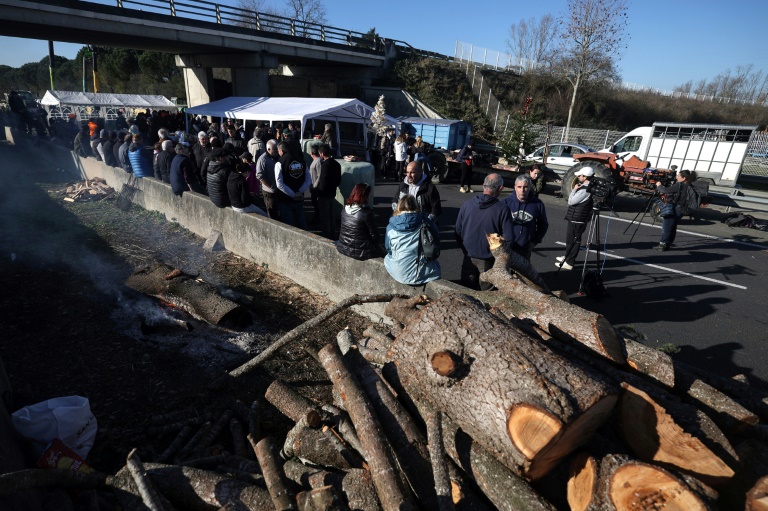 Le 13 décembre 2025, à Carbonne, dans le sud-ouest de la France, un mur de paille et des tracteurs bloquent l'accès à l'autoroute A64, pour protester contre les mesures sanitaires face à la dermatose nodulaire contagieuse