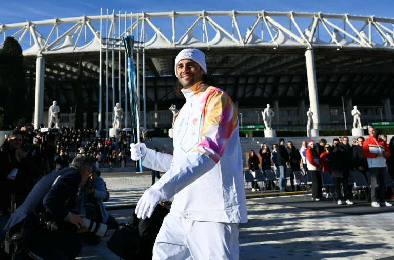 L'athlète italien spécialiste du saut en hauteur Gianmarco Tamberi tient la torche des Jeux Olympiques de Milan-Cortina 2026, à Rome, le 6 décembre 2025