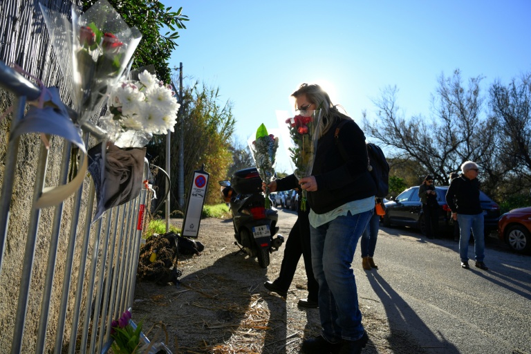 Une femme dépose des fleurs en hommage à Brigitte Bardot à l'entrée de sa propriété de Saint-Tropez, le 28 décembre 2025