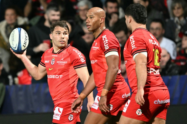 Le joueur de l'équipe du Stade Toulousain de rugby Antoine Dupont (à gauche) tient la balle lors du match de Champions Cup contre l'équipe sud-africaine des Hollywoodbets Sharks au stade Ernest Wallon à Toulouse le 7 décembre 2025.