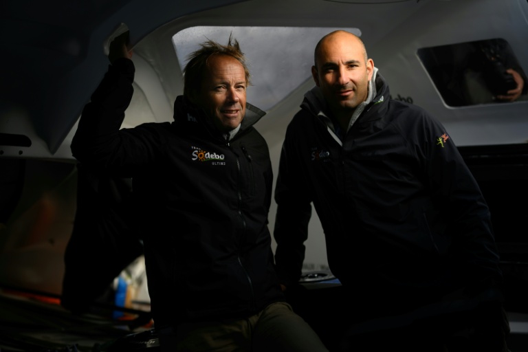 Les skippers français Thomas Coville (à gauche) et Benjamin Schwartz posent à bord du multicoque Sodebo Ultim 3, deux jours avant le départ de la Transat Café L'Or, au Havre, le 24 octobre 2025