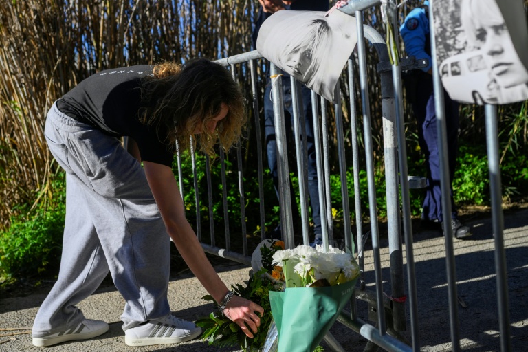Une femme dépose un bouquet de fleurs en hommage à Brigitte Bardot à l'entrée de la propriété de la star décédée à Saint-Tropez, le 28 décembre 2025