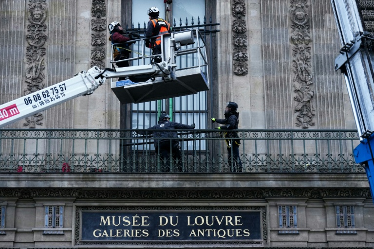 Des ouvriers installent une grille de protection devant la fenêtre de la galerie d'Apollon du  musée du Louvre, le 23 décembre 2025 à Paris