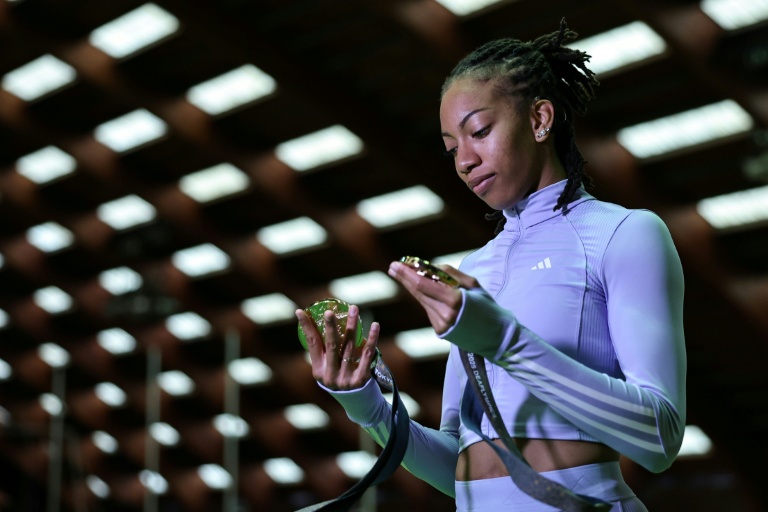 La sprinteuse française Paméra Losange, sourde de naissance, pose avec les deux médailles d'or obtenues lors des Deaflympics de Tokyo 2025 lors d'une séance d'entrainement à l'Institut du Sport, Expertise et Performance (INSEP) à Paris le 10 décembre 2025.