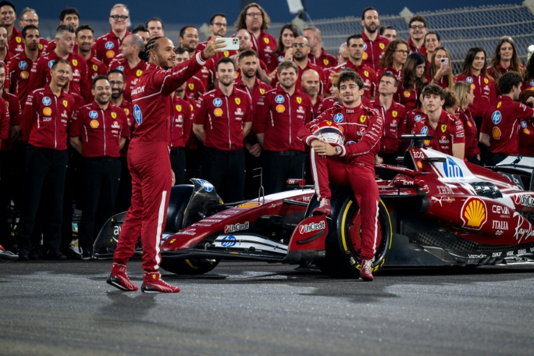 Lewis Hamilton (g) et Charles Leclerc (d) posent pour une photo avec l'équipe Ferrari avant le dernier Grand Prix de la saison, le 4 décembre 2025 à Abou Dhabi