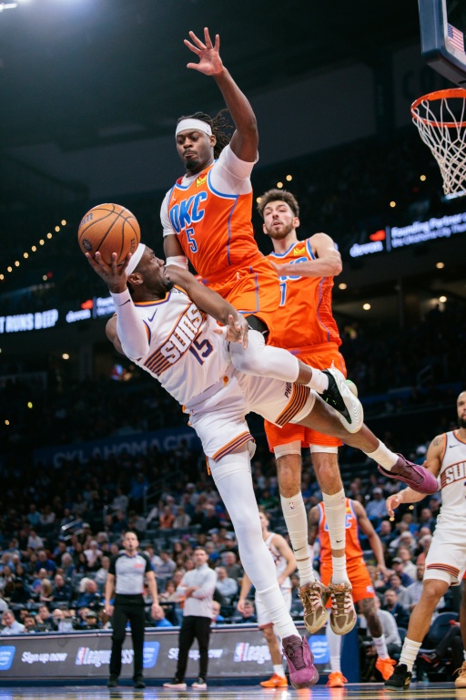 Luguentz Dort (c) défend sur Mark Williams (g) lors du match NBA entre l'Oklahoma City Thunder et les Phoenix Suns, le 10 décembre 2025 à Oklahoma City