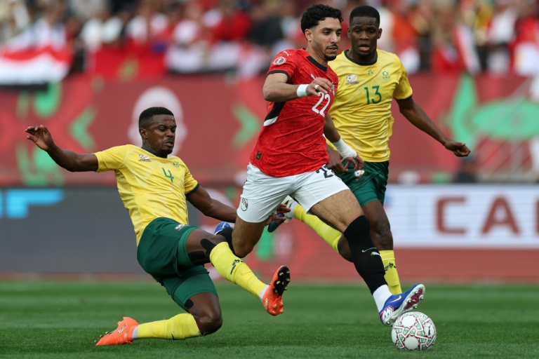 L'attaquant égyptien Omar Marmoush s'infiltre entre deux défenseurs sud-africains, lors d'un match de la CAN, le 26 décembre 2025 à Agadir (Maroc)