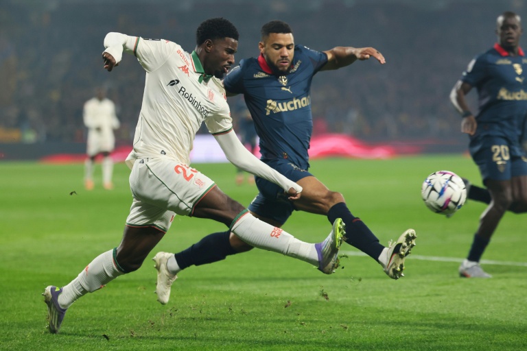 L'attaquant niçois Mohamed-Ali Cho (G) et le défenseur lensois  Matthieu Udol lors de la victoire lensoise 2-0, le 14 décembre 2025 à Lens