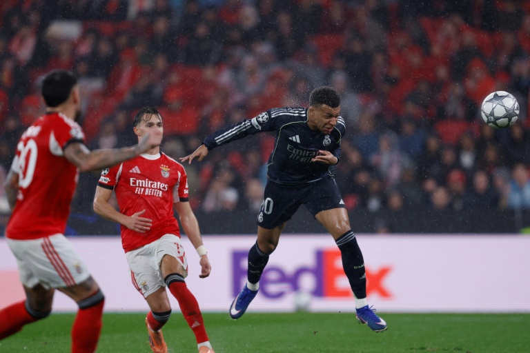 L'attaquant français du Real Madrid Kylian Mbappe marque de la tête le premier but de son équipe contre Benfica en Ligue des champions mercredi au stade de la Luz à Lisbonne.