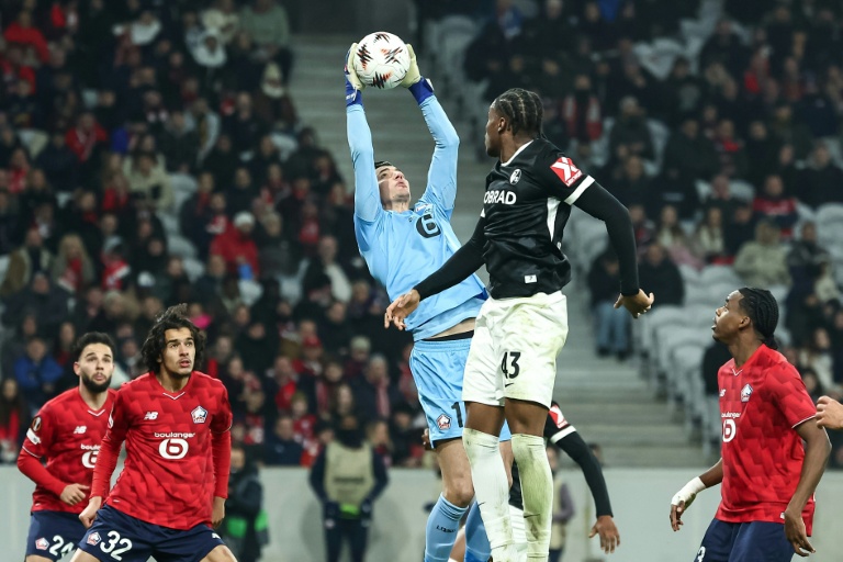 Le gardien turc de Lille Berke Ozer (C) s'impose dans les airs face aux attaquants de Fribourg (1-0), le 29 janvier 2026 lors de l'ultime journée de phase de ligue de la Ligue Europa à Villeneuve-d'Ascq