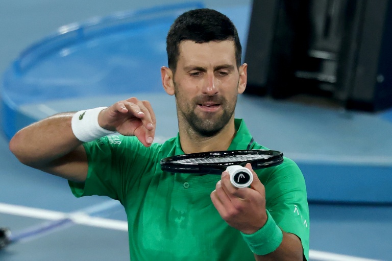 Le Serbe Novak Djokovic joue du violon sur sa raquette pour célébrer sa victoire contre le Néerlandais Botic van de Zandschulp samedi 24 janvier 2026 à l'Australian Open à Melbourne