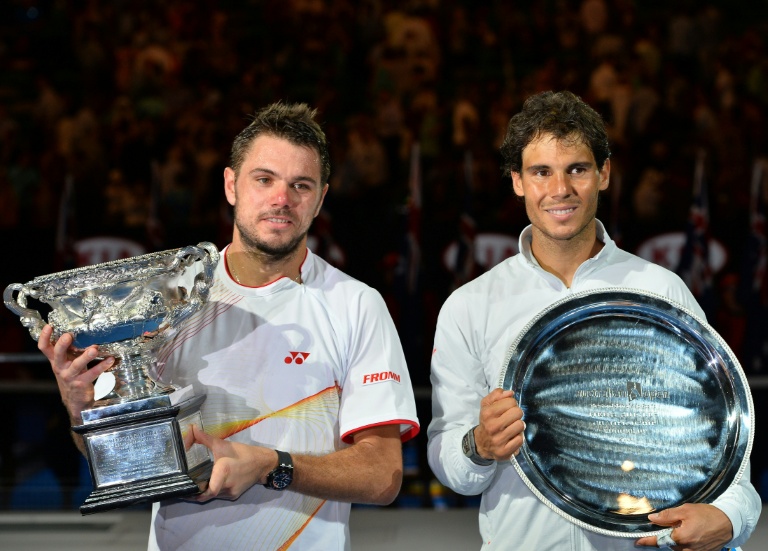 Le Suisse Stanislas Wawrinka (à gauche) pose avec le trophée du vainqueur aux côtés de l'Espagnol Rafael Nadal à l'issue de la finale de l'Open d'Australie 2014, à Melbourne, le 26 janvier 2014
