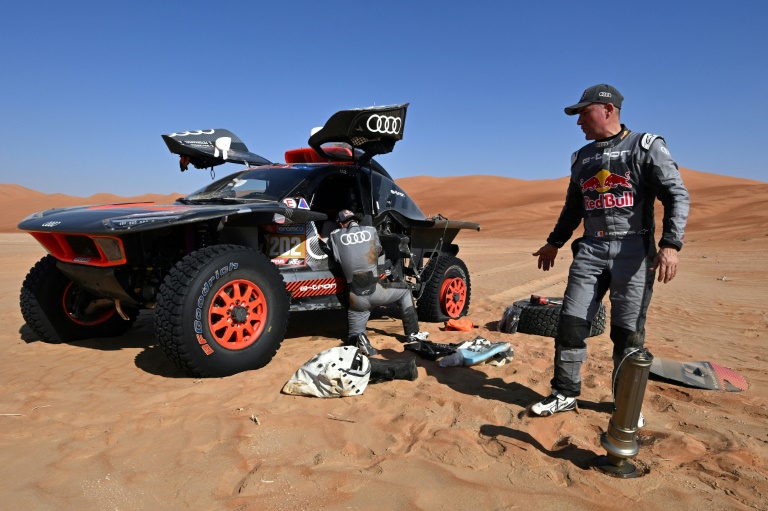 Le pilote français Stéphane Peterhansel (d) répare son véhicule avec son copilote Edouard Boulanger, lors de l'édition 2024 du Rallye-Dakar, en Arabie saoudite