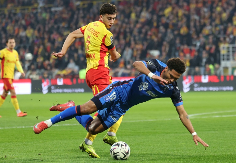 Le milieu monténégrin de Lens Andrija Bulatovic se heurte à l'attaquant camerounais d'Auxerre Danny Namaso en L1 le 17 janvier 2026 à Lens