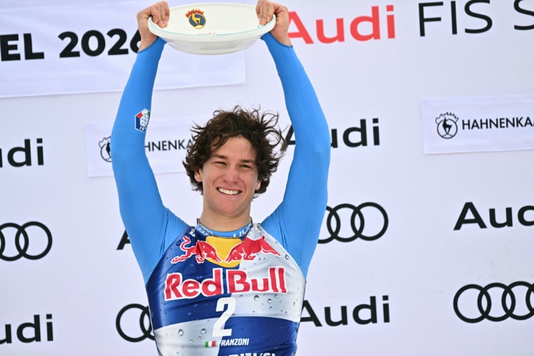L'Italien Giovanni Franzoni célèbre sur le podium sa victoire dans la descente de la manche de Coupe du Monde de Kitzbühel (Autriche), le 24 janvier 2026