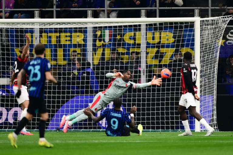 Le gardien de l'AC Milan Mike Maignan stoppe un tir de son compatriote Marcus Thuram lors du match du Championnat d'Italie contre l'Inter le 23 novembre 2025 à San Siro