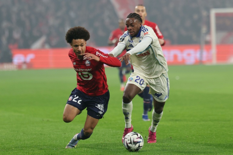 Le défenseur de Lille Tiago Santos (G) et l'attaquant strasbourgeois Martial Gogo lors de la victoire strasbourgeoise 4-1 en Ligue 1, le 25 janvier 2026 au Stade Pierre-Mauroy de Villeneuve-d'Ascq