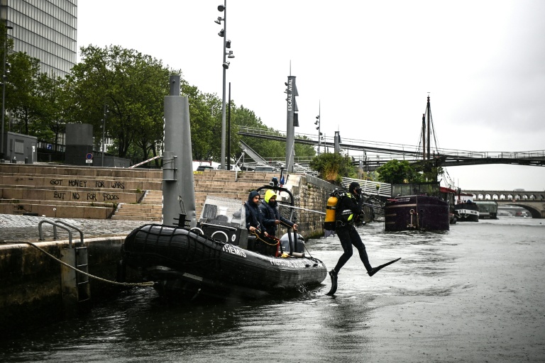 Un plongeur de la brigade fluviale saute dans la Seine depuis un bateau de patrouille à Paris, le 9 mai 2023