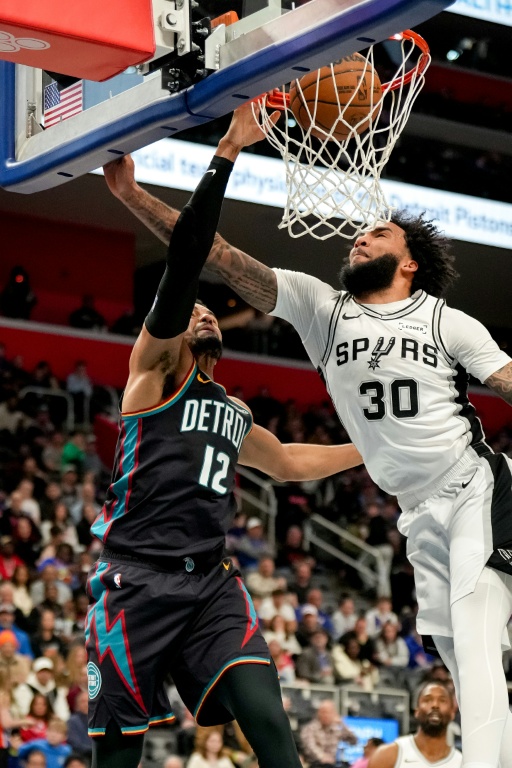 Tobias Harris (g) marque pour les Detroit Pistons malgré la défense de Julian Champagnie des San Antonio Spurs, le 23 février 2026 à Détroit en NBA