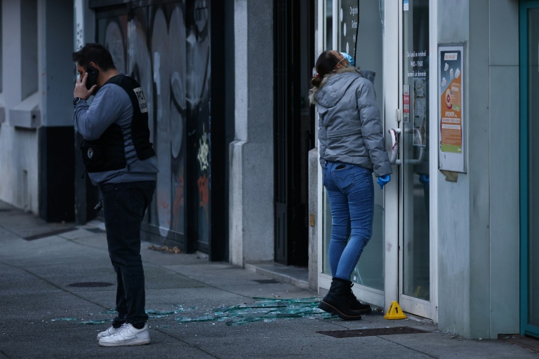 Des policiers examinent la vitrine d'un salon de beauté contre lequel une grenade a été lancée à Grenoble, le 6 février 2026 en Isère