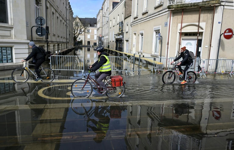 Des cyclistes dans une rue inondée d'Angers, le 20 février 2026