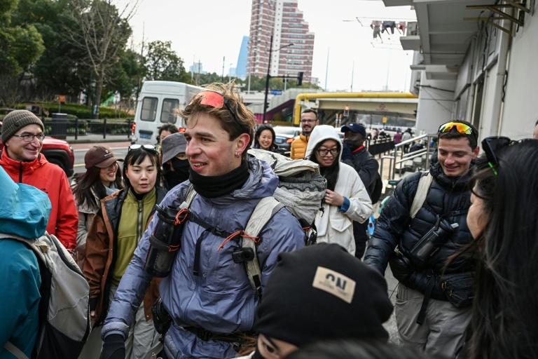 Loïc Voisot (G) et Benjamin Humblot (D) dans une rue de Shanghai le 7 février 2026, après leur périple à pied depuis la France