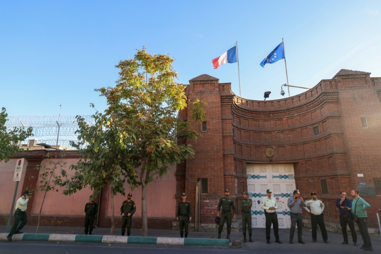 Des membres des forces de sécurité iraniennes montent la garde devant l'ambassade de France à Téhéran, le 21 octobre 2025, lors d'une manifestation de soutien à l'Iranienne Mahdieh Esfandiari, arrêtée en France