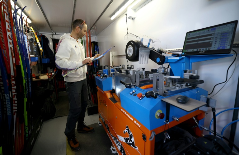 Un technicien de l'équipe de France de ski de fond prépare un ski dans son atelier mobile d'environ 60 m2 à l'intérieur d'un semi-remorque, le 17 février avant une épreuve des JO de Milan Cortina à Tesero