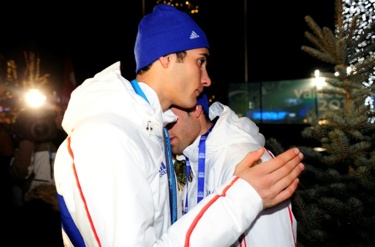 Le médaillé d'argent français Martin Fourcade (à gauche) réconforte son frère Simon après la cérémonie de remise des médailles du 15 km mass start du biathlon masculin pendant les Jeux olympiques d'hiver de Vancouver, le 21 février 2010