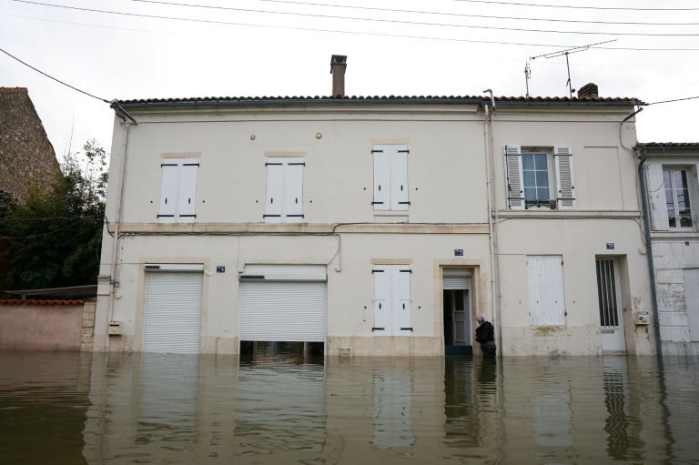 Un habitant pénètre dans une habitation inondée par les crues, le 18 février 2026 à Saintes, en Charente-Maritime