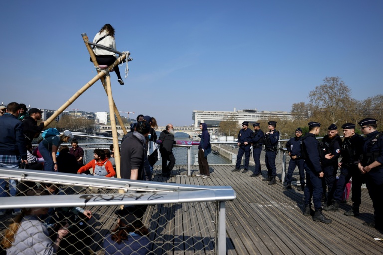 Des militants du groupe écologiste Extinction Rebellion (XR) occupent la passerelle Simone-de-Beauvoir à Paris, le 21 mars 2026