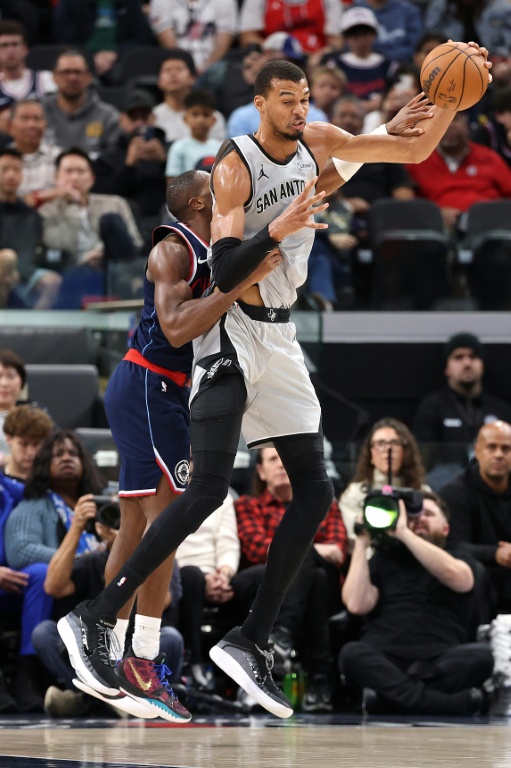 Kris Dunn (g) défend sur Victor Wembanyama lors du match NBA entre les Los Angeles Clippers et les San Antonio Spurs, le 16 mars 2026 à Inglewood